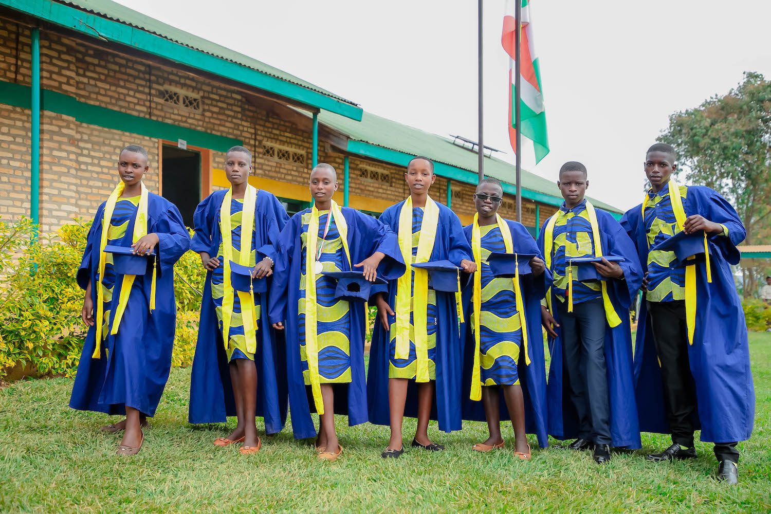group of graduates in blue and yellow gowns