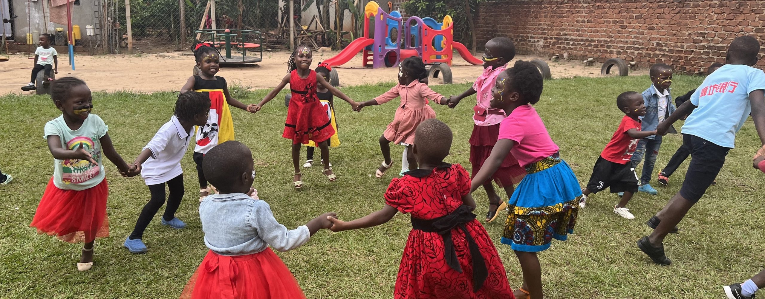 children dancing in a circle at the NGO enjuba in Uganda