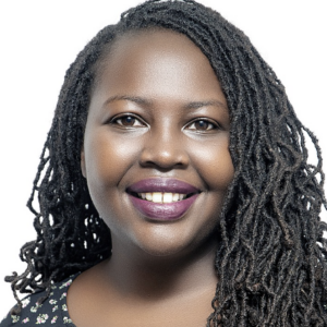 Safaa Garelnabi smiling at camera with hair down over one shoulder in front of white backdrop
